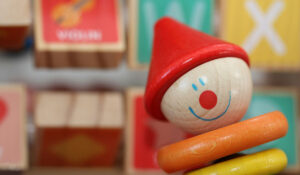 Närbild på en träclown med röd hatt och glatt ansikte